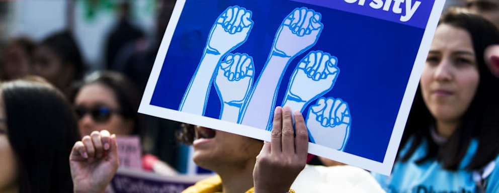 A demonstrator supporting Harvard University's admission process holds a sign that reads "Defend Diversity" during a protest