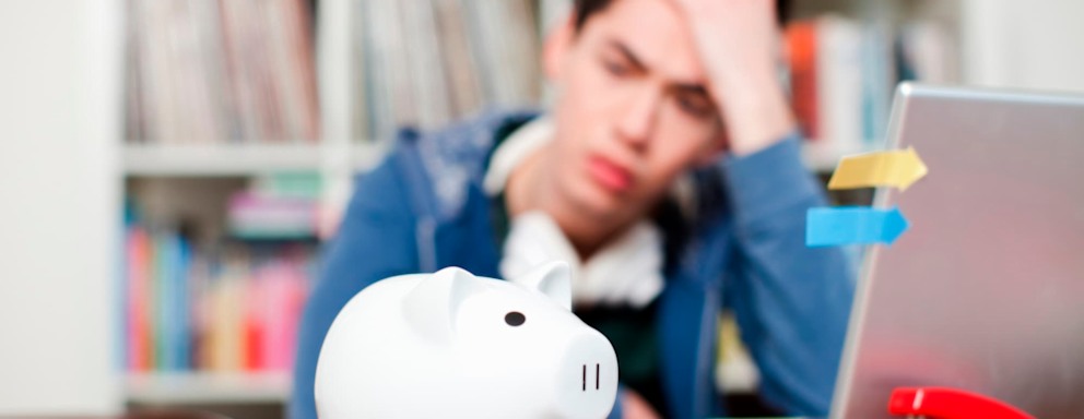 Piggy bank with young man worrying in background